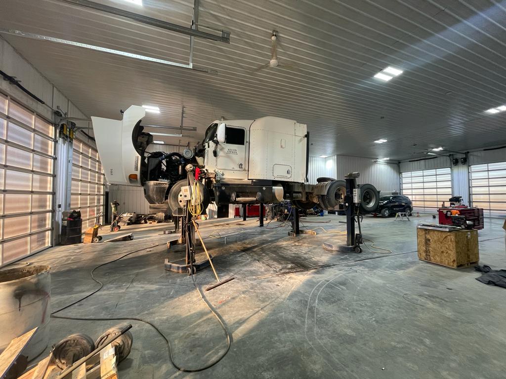White semi cab on hoist in Hwy 32 shop
